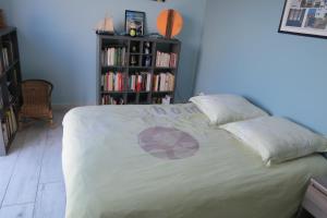1 dormitorio con 1 cama y estantería con libros en Chambre chez Marie avec vue imprenable, en Sainte-Feyre
