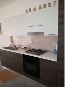 a kitchen with white cabinets and a stove top oven at Casa Sara Boavista in Sal Rei