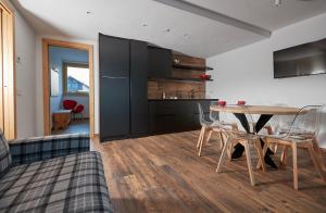 a kitchen and dining room with a table and chairs at Al Bait Ross in Bormio