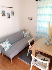 a living room with a couch and a table at Apartman Barbara in Cres
