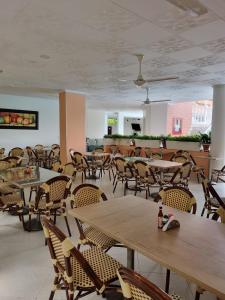 an empty restaurant with tables and chairs and a ceiling at Zahira Hotel Melgar in Melgar