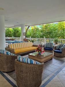 a patio with couches and chairs and a table at Zahira Hotel Melgar in Melgar