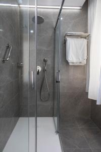 a bathroom with a shower with a glass door at Hotel Olimpo in Isla