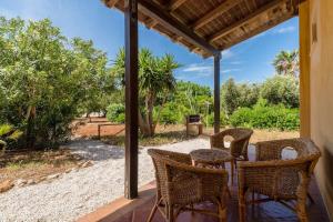 a patio with wicker chairs and a table on a porch at I Giardini Di San Vito in San Vito lo Capo