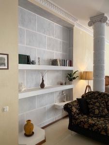 uma sala de estar com prateleiras brancas e um sofá em Просторная солнечная студия с круглым балконом em Vyborg