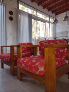 sala de estar con 2 sillas y mesa en ILUSIONES Bosque y Mar en Mar de las Pampas
