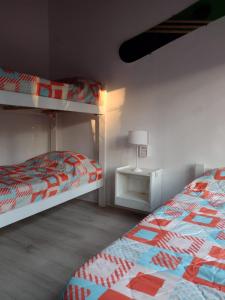 a bedroom with two bunk beds and a lamp at ILUSIONES Bosque y Mar in Mar de las Pampas