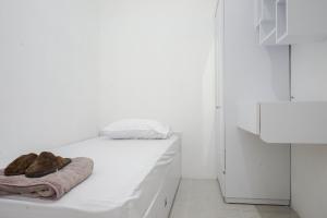 a white room with a bed with a towel on it at Omah Ninten Syariah RedPartner in Solo