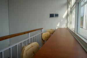 a balcony with a long wooden table and two chairs at Omah Ninten Syariah RedPartner in Solo