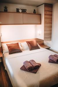 un grande letto bianco con due asciugamani sopra di Mobile Home Kailani Nr 121, Camping Porton Biondi a Rovigno (Rovinj)
