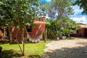 uma casa com rede em frente a um quintal em Pequizeiro Eco Pousada em Cavalcante