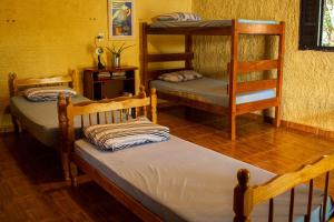 a room with two bunk beds and a table at Pequizeiro Eco Pousada in Cavalcante