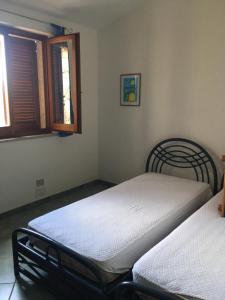アリエントゥにあるCasa Vacanze Paradisoのベッドルーム1室(ベッド2台、窓付)