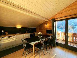a kitchen with a dining room table and chairs at Café-Hôtel Le Morillon, Domaine du Grand Massif-Samoëns in Morillon +96 photos