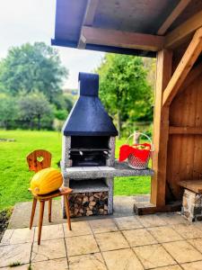 a wood fired oven on a patio with a chair at Chaloupka u Splavu in Loučná nad Desnou