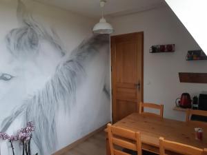 une salle à manger avec une fresque murale en plumes. dans l'établissement Relais équestre du Miloir - chambres d'hôtes, à Saint-Martin-de-la-Lieue