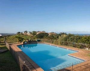 a large swimming pool with a fence around it at V's studio in Ballito
