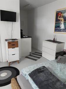 Schlafzimmer mit weißen Möbeln und einem Flachbild-TV in der Unterkunft Appartement im Hasental in Garmisch-Partenkirchen