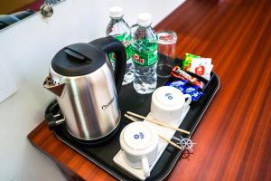 - un plateau/bouilloire avec des tasses sur une table dans l'établissement Grande Ave Maria Resort, à Candolim