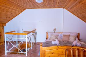 a bed in a room with a wooden ceiling at Délibáb Vendégház in Szigliget +19 photos