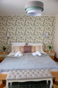 ein Schlafzimmer mit einem großen Bett mit zwei Handtüchern darauf in der Unterkunft Délibáb Apartman in Szigliget