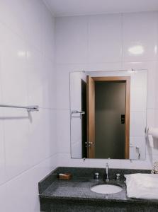 a bathroom with a sink and a mirror at Esplanada Brasilia Hotel e Eventos in Brasília