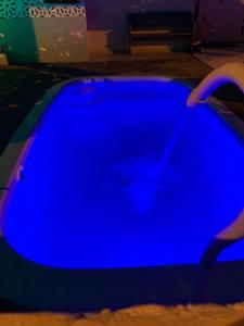 a blue swimming pool in a dark room at Casa cinza in Aracaju