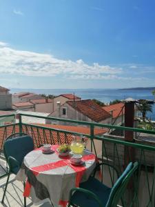 una mesa en un balcón con vistas al océano en Apartments Melinda, en Baška Voda