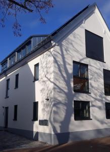 ein weißes Gebäude mit einem Schatten auf der Seite in der Unterkunft Flat11 4-Zi Wohnung Messe Karlsruhe in Rheinstetten