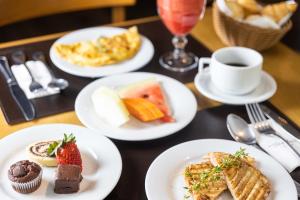 a table with plates of food and a cup of coffee at Radisson Oscar Freire in Sao Paulo