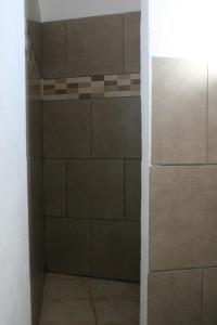 ducha a ras de suelo con azulejos marrones en La Palma Hostel by Pension Central, en Fuencaliente de la Palma