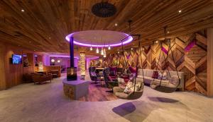 a lobby with a bunch of chairs and a chandelier at Superior Sport und Familienresort Alpenblick in Zell am See +153 photos