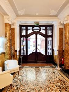 eine Lobby mit einer großen Holztür und einer Couch in der Unterkunft Green Class Hotel Astoria in Turin