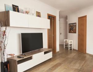 a living room with a television on a wall at Villa Eliza in Denia