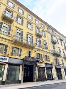 a large yellow building on a city street at Hotel Astoria in Turin +14 photos