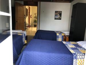 a bedroom with two beds and a hallway with a table at Hostel Lit Guadalajara in Guadalajara