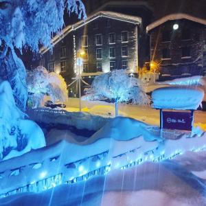 una ciudad cubierta de nieve por la noche en Hotel Montané en Arinsal