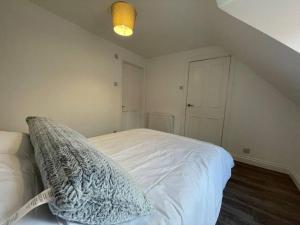 a bedroom with a white bed with a pillow on it at Argyle House - Stunning 2 Bed Cottage In Eyemouth in Eyemouth