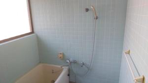 Guest house HIRO - Vacation STAY 08973v في Zōshuku: حمام مع حوض استحمام ودش ذو بلاط ازرق