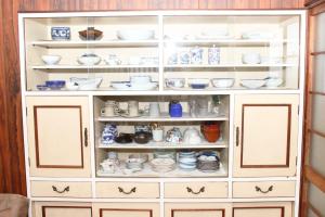 Guest house HIRO - Vacation STAY 08973v في Zōshuku: خزانة بيضاء مليئة بالأطباق والأطباق