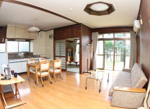 Guest house HIRO - Vacation STAY 08973v في Zōshuku: مطبخ وغرفة معيشة مع طاولة وكراسي