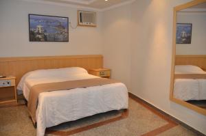 um quarto com 2 camas e um espelho em Saionara Hotel no Rio de Janeiro