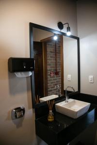 ein Bad mit einem Waschbecken und einem Spiegel in der Unterkunft Villagio Santa Tereza in Vacaria