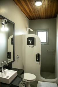 ein Badezimmer mit einem Waschbecken, einem WC und einem Spiegel in der Unterkunft Villagio Santa Tereza in Vacaria