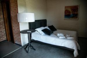 ein Schlafzimmer mit einem Bett mit einem Tisch und einer Lampe in der Unterkunft Villagio Santa Tereza in Vacaria