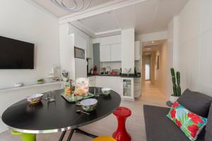 uma sala de estar com uma mesa preta e uma cozinha em Immeuble Villa PIRON em Nice
