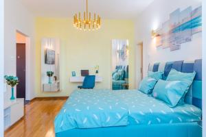 Un dormitorio azul con una cama azul y una lámpara de araña. en New Studio Carturesti - City Center en Bucarest
