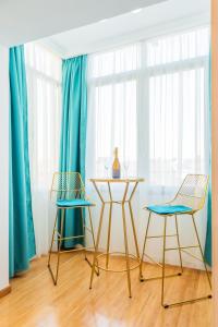 a table and two chairs in a room with blue curtains at New Studio Carturesti - City Center in Bucharest