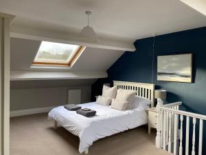 a bedroom with a white bed and a window at Town House In The Heart of Pateley Bridge in Pateley Bridge