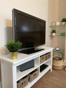 a flat screen tv on a white entertainment center at Town House In The Heart of Pateley Bridge in Pateley Bridge